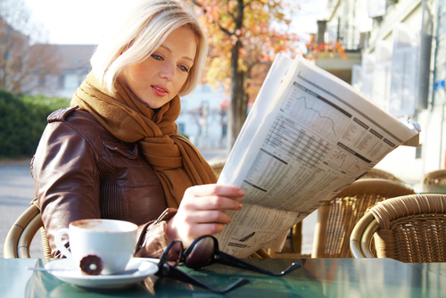 young woman reading the newspaper